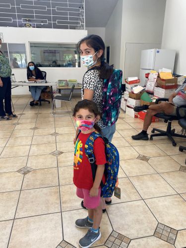 Elementary and preschool girls with backpacks